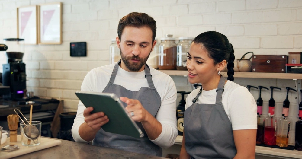 Restaurant staff using digital tablet for order and inventory management